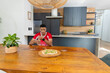 © wavebreak3 - African American man in red shirt with watch, sitting at wooden table holding bottle near pizza
