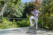 © wavebreak3 - Adult African American man balancing on mat on deck wearing lilac tee, smartwatch, copy space