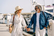 © Carlos Rodelas Media - Happy senior couple enjoying summer vacation in luxury marina mature couple walking hand in hand enjoying luxury lifestyle