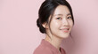 © Aekpawee - Charming Asian woman with elegant hair bun smiling beautifully in pink dress, natural beauty and skincare portrait