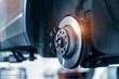 © Parilov - Closeup of steel brake disc in car service. Concept for replacing wheel pads in garage.