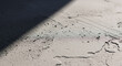 © MstManoara - A close-up view of textured cimento queimado surface showing detailed grainy patterns with natural light and shadow creating a modern industrial interior