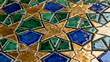 © Iruzzayne - A close-up of blue, green, and gold glazed ceramic tiles forming intricate star-shaped mosaic pattern.