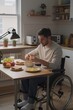 © Michael - A man in a manual wheelchair prepares breakfast in his modern kitchen, surrounded by natural light and warm colors.