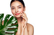 © Oleg Gekman - Close up woman face with green exotic leaf. Skin care beauty treatments concept. Model with clean, health skin of face. Monstera Leaves