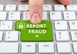 © Creative's Buddy - Finger pressing a green report fraud key on a computer keyboard