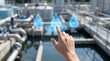 © dhiyaulhaq - Human hand selecting holographic water droplet icon over treatment facility for smart water management