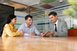 © fizkes - Financial advisor presenting commercial offer, consulting adult multiethnic couple during office meeting, showing investment proposal on digital tablet. Professional client services, consultation