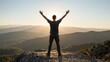 © Babb - Man raising arms at sunrise on rocky mountain overlook