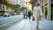 © Not_nutthapong - Stylish woman city street urban fashion business walking elegant confident Mature professional walking along clean city sidewalk, wearing beige