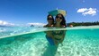 © Cak - Two women in swimwear pose under and above crystal-clear turquoise water
