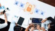 © InfiniteFlow - A top-down view of a business meeting focused on digital security, featuring collaborative efforts on a laptop displaying charts and data analytics for improved cybersecurity strategies. Raster