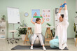 © Pixel-Shot - Female osteopath and little patient with elastic bands doing exercises on fit ball in clinic