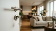 © Abu - Open door with key in lock and home keychain, revealing bright modern living room