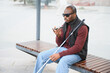 © Serhii - Blind african american man using voice assistant