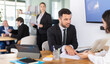 © JackF - Professional adult male lawyer or bank employee talking and signing loan agreement with young woman client in modern bank