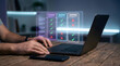© Eugine - Person using laptop with glowing holographic comparison checklist table for feature plan selection concept in dark office