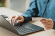 © Garun Studios - Person using credit card for online shopping on laptop, representing digital payment, e-commerce, cashless transaction, secure banking, and modern financial technology.
