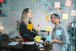 © Kornkanok - Colleagues Brainstorming Ideas with Sticky Notes on Glass Board