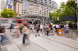 © Austockphoto - Busy urban street with people and reed tram in motion blur