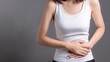 © Mi - Woman Pressing Abdomen with Hands Showing Stomach Pain, Gastrointestinal Disease and Menstrual Cramps, Medical Health Concept