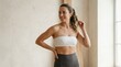 © Svitlana - Fit woman wearing a strapless white bra, showcasing smooth skin and toned body, clean beauty styling, modern body confidence and wellness concept, minimal studio background, soft natural light,
