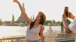 © blueringmedia - Young Woman Posing for Smartphone Photo by Wat Arun at Sunset