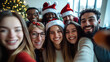 © Nan Shen - Diverse group of happy young business people or friends taking a selfie photo on smartphone during a christmas party in a modern office.