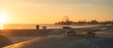 Skateboard on concrete ramp at beach skatepark with Santa Monica pier silhouette during golden hour sunset