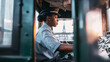 © Bonsales - Black woman tram driver operating vintage train control cabin with green panels, focused on journey