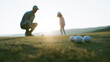 © Bonsales - Golf coach guiding kid, teaching putting in a positive environment. Golf balls on green with sun flare