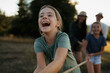 © Halfpoint - Family playing tug of war together outdoors during fun summer day.