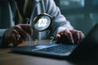 © Looker_Studio - Business professional using a laptop while examining an AI chip through a magnifying glass, representing smart tool selection, technology research, automation strategy, and digital innovation.