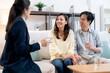 © NT_studio - Counselor writing on clipboard during consultation, asian couple holding hands and sitting on sofa, taking notes while discussing relationship advice, mental health therapy and marriage counseling.