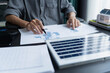 © Wanda - Electrical engineer working on solar panel blueprint sustainable energy