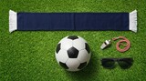 Flat lay of football game essentials including a ball, scarf, whistle, and sunglasses
