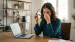 © Sajedul - Stressed woman working on laptop at home office with headache and fatigue
