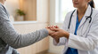 © Sajedul - Doctor holding elderly patient's hands in comforting consultation at clinic