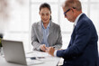© David - Business people collaborating on a desktop, analyzing financial reports and charts with a laptop nearby, discussing strategies, and planning for success in a modern office setup