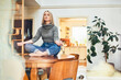 © baranq - Woman meditating in lotus pose on dining table at home