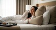 © RONNY - Woman Relaxing in Luxurious Hotel Bed with Breakfast Tray.