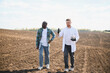 © Serhii - Agronomist and farmer discussing soil analysis in field