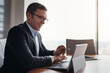 © peopleimages.com - Laptop, paperwork and business man in office for research, stock trading and finance report. Corporate, financial advisor and person with computer for investor career, planning and budget review