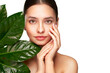 © Oleg Gekman - Close up woman face with green exotic leaf. Skin care beauty treatments concept. Model with clean, health skin of face