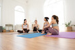 © Hip.hub - Group of friends talking and enjoying yoga practice in a bright studio during the day