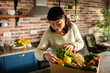 © Davor - Woman unpacking farm fresh vegetables in home kitchen