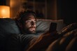 © spyrakot - Late night digital lifestyle adult male scrolling phone while resting on pillows