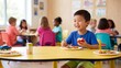 © detry26 - Asian boy smiling while holding red apple at kindergarten lunch table. Healthy school meal time, nutrition education and social interaction concept