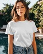 © Vitalii - Young woman wearing plain white t shirt standing outdoors near swimming pool in resort setting with natural sunlight. Clean front view highlights apparel mockup for logo placement and fashion branding