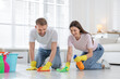 © New Africa - Spring cleaning. Couple tidying up floor together at home